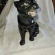 Statue of a roaring panther/leopard sitting in black glazed ceramic.