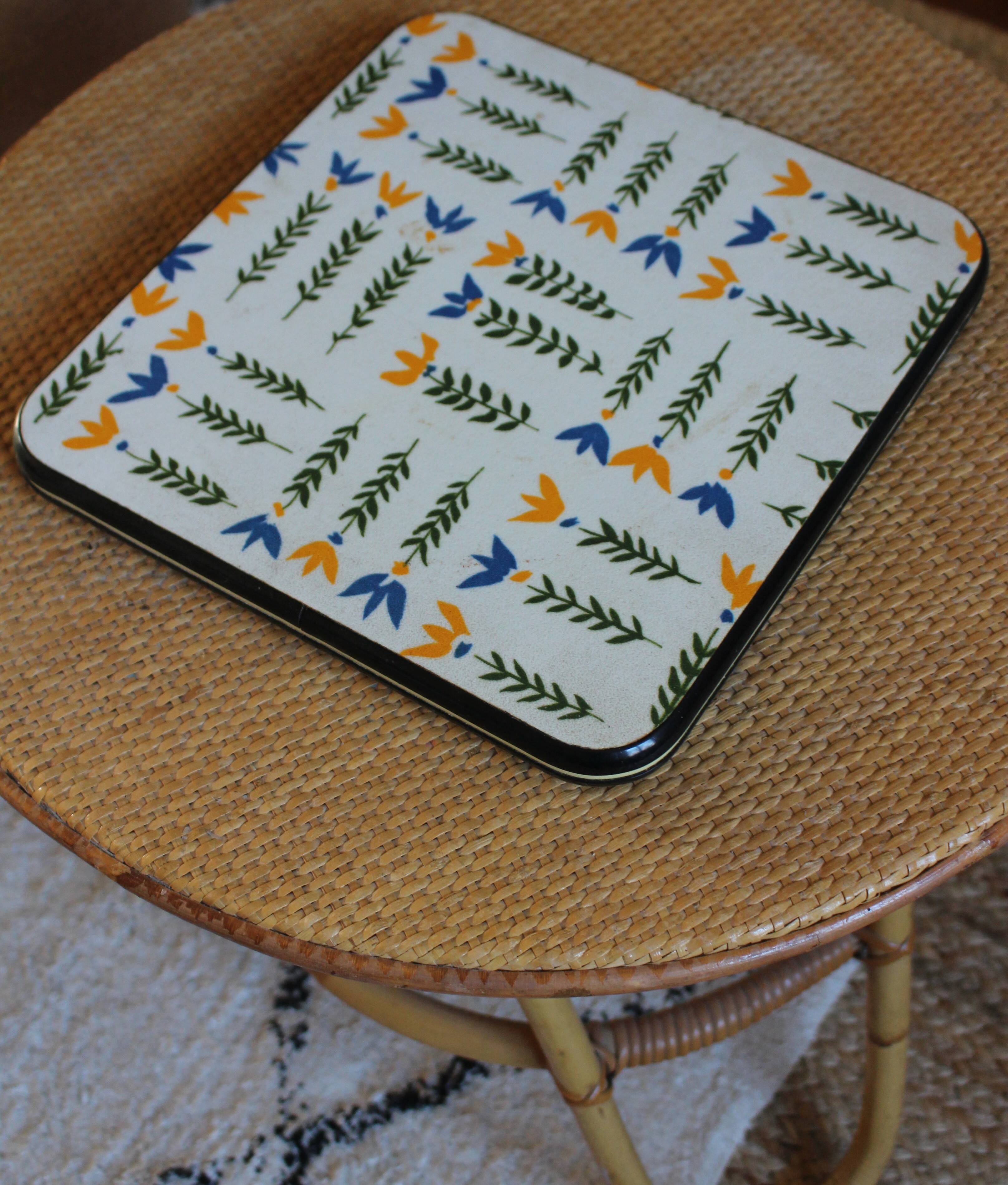 Vintage laminated wooden trivet with yellow, green, and blue flowers