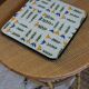 Vintage laminated wooden trivet with yellow, green, and blue flowers