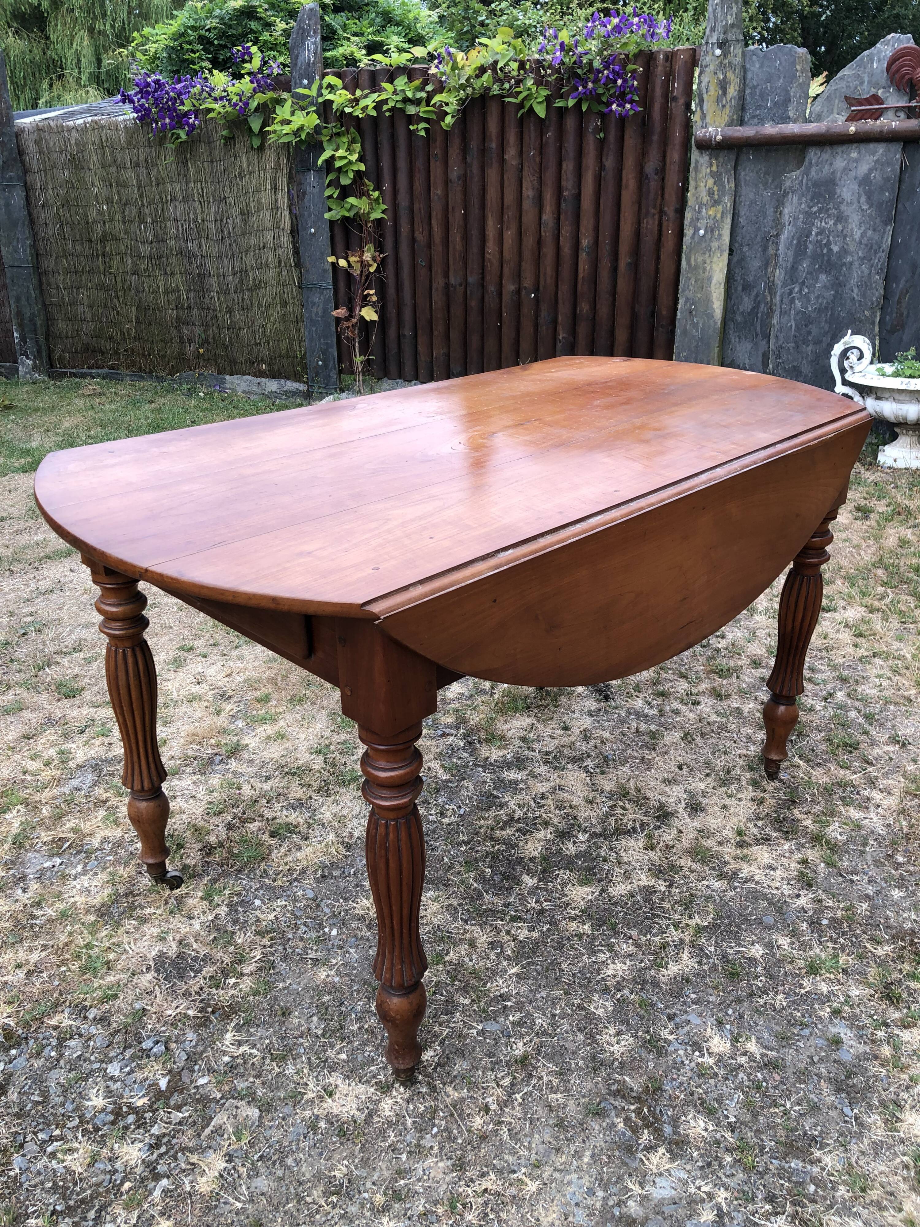 Louis Philippe oval drop-leaf table in solid cherry wood with 2 drawers.