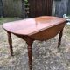 Louis Philippe oval drop-leaf table in solid cherry wood with 2 drawers.
