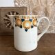 Old ceramic pitcher with orange decoration.