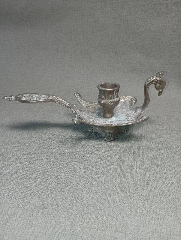 Chiselled brass candlestick in the shape of a peacock.