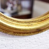 Golden oval mirror with leaf
