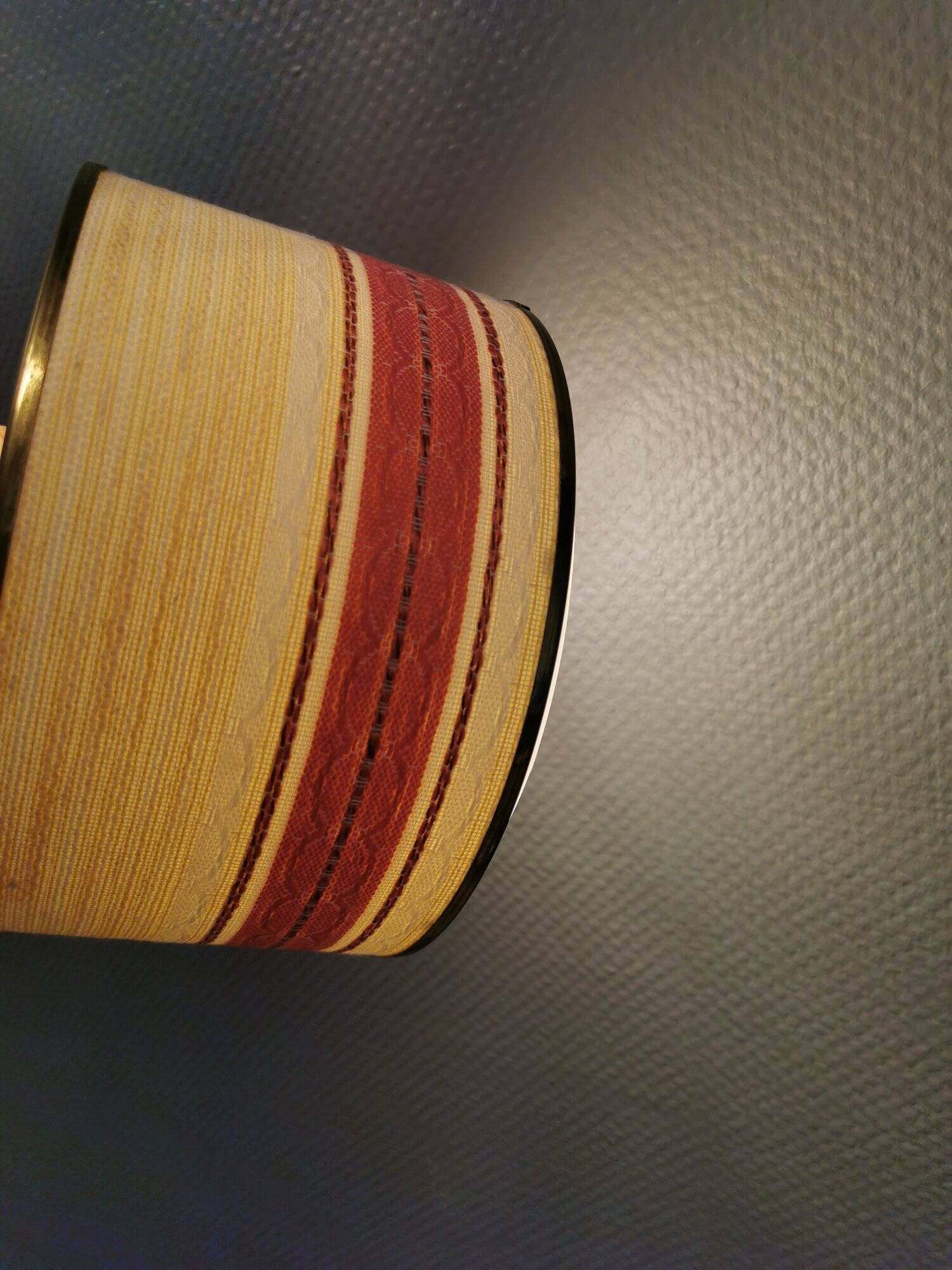 Hanging lamp with brass-coloured details, made of fabric with intact plastic bottom grille.