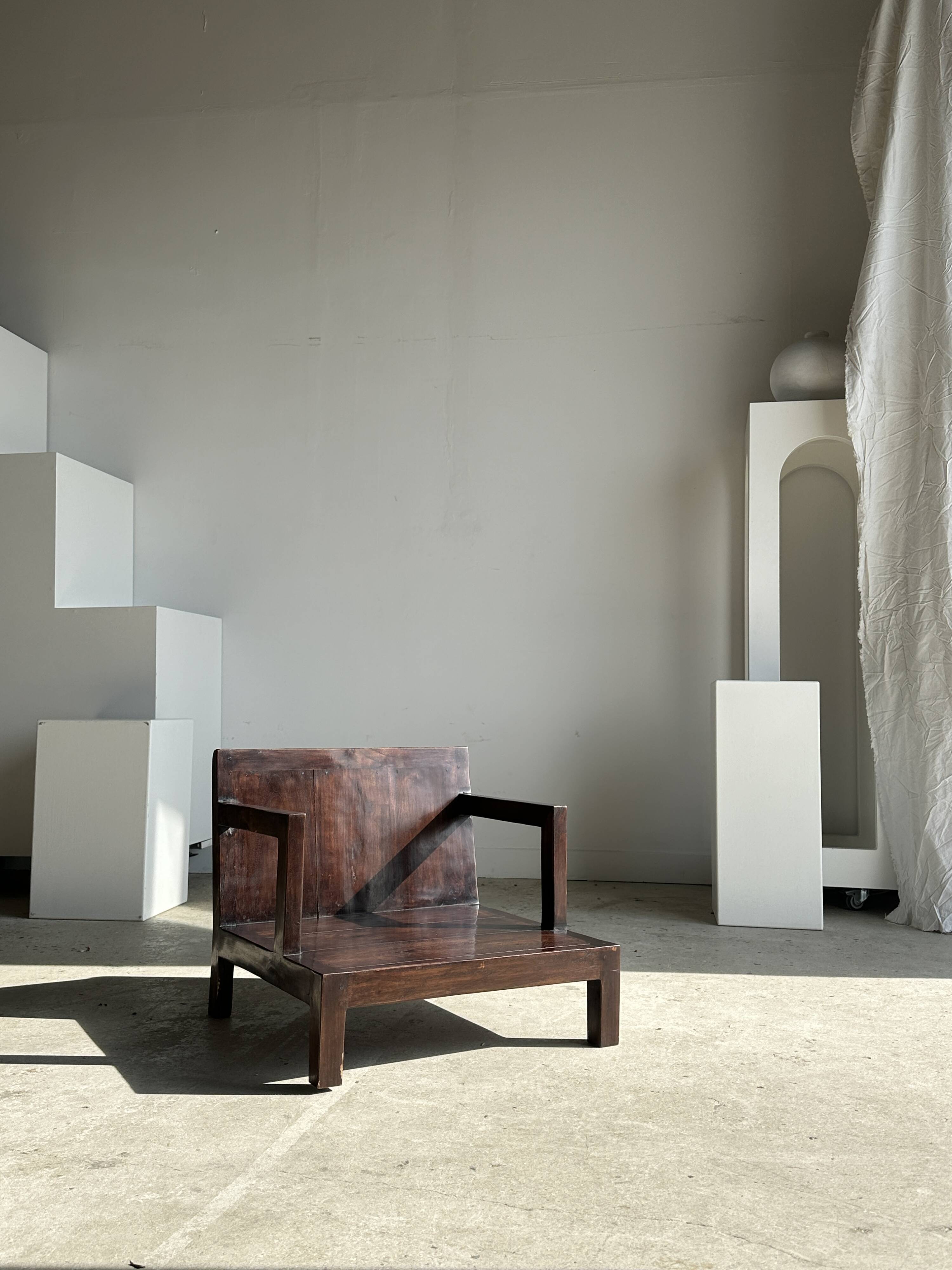 Small low armchair in varnished brown wood