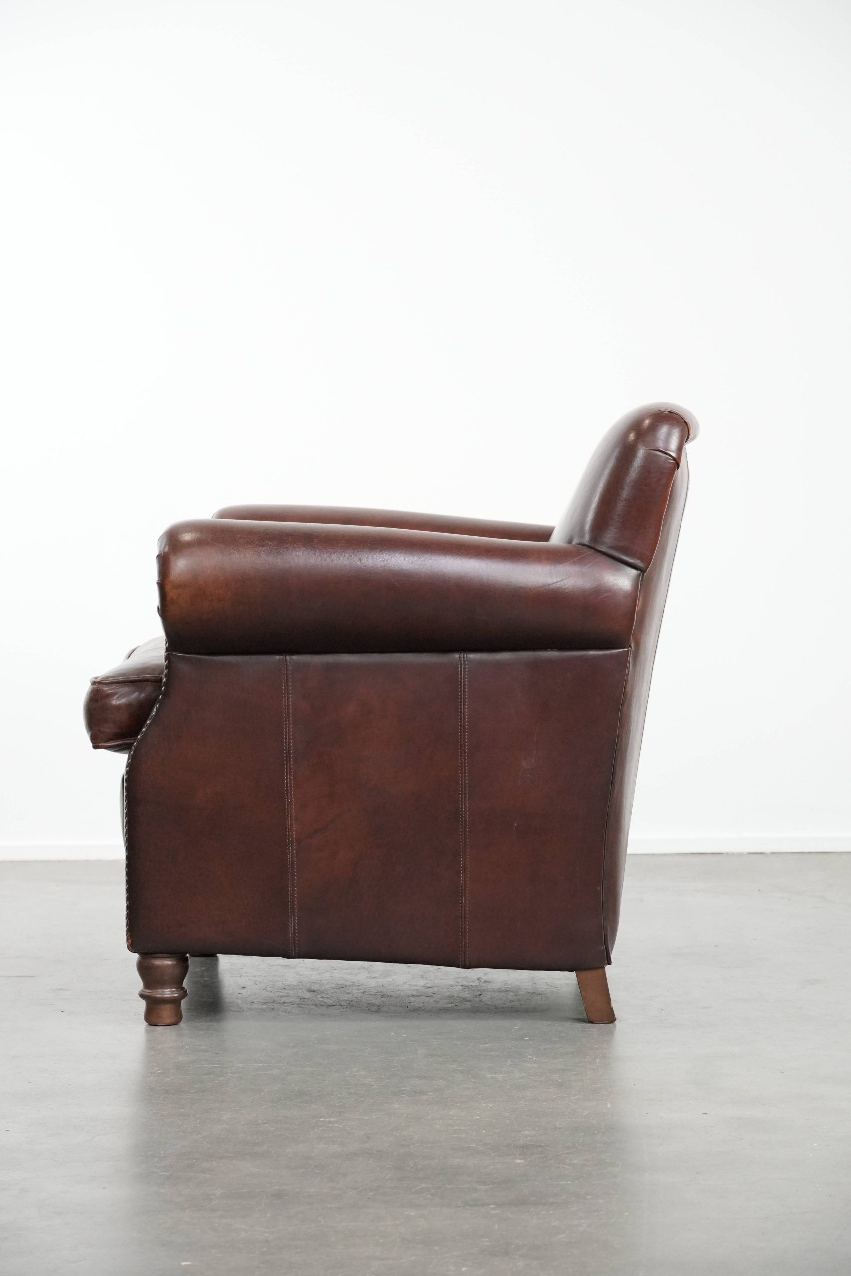 Sheepskin armchair with a classic finish and decorative studs.