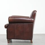 Sheepskin armchair with a classic finish and decorative studs.