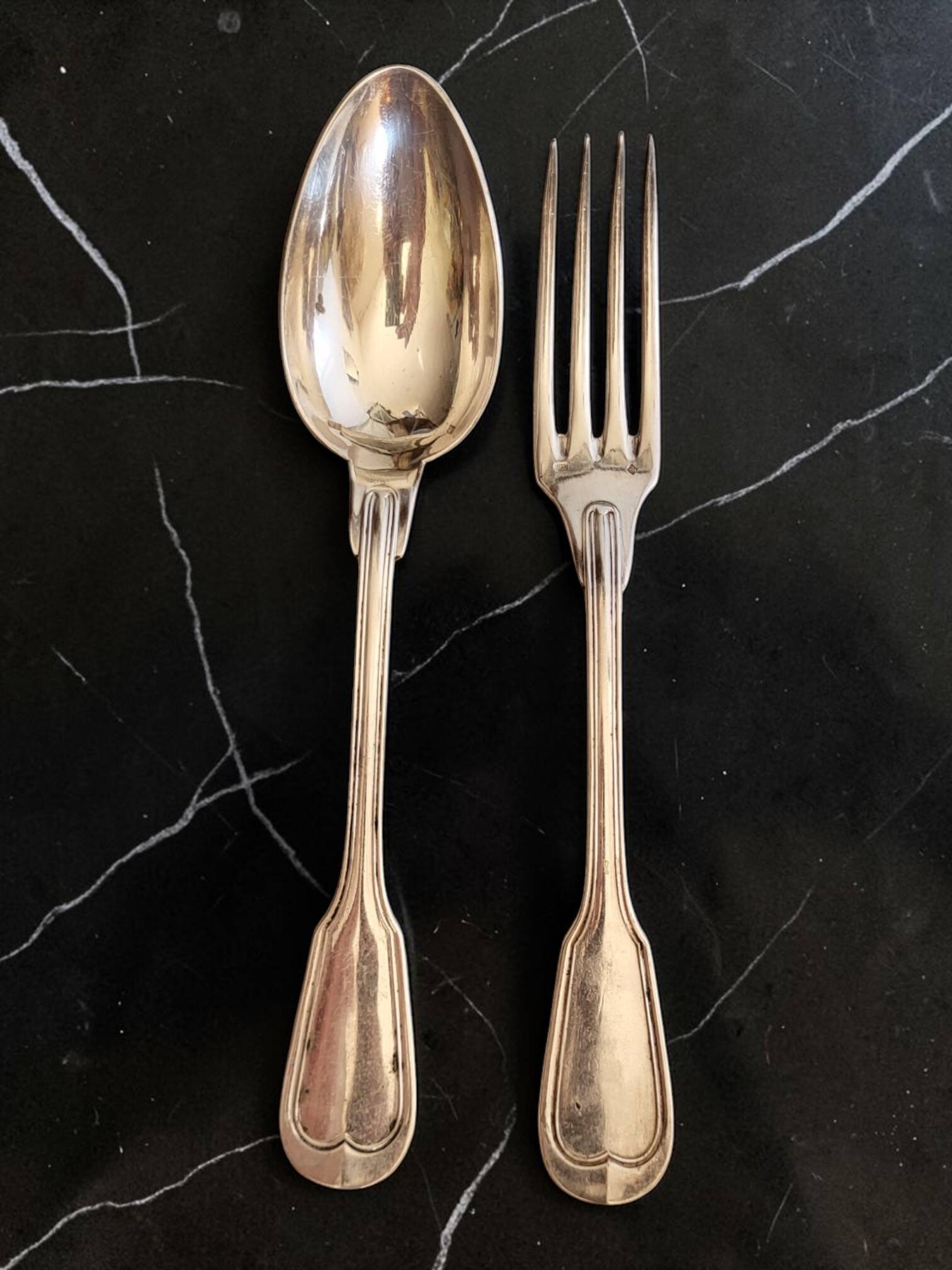 24 silver-plated metal table settings in the filet model.