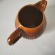 Caramel slipware pitcher with braided relief