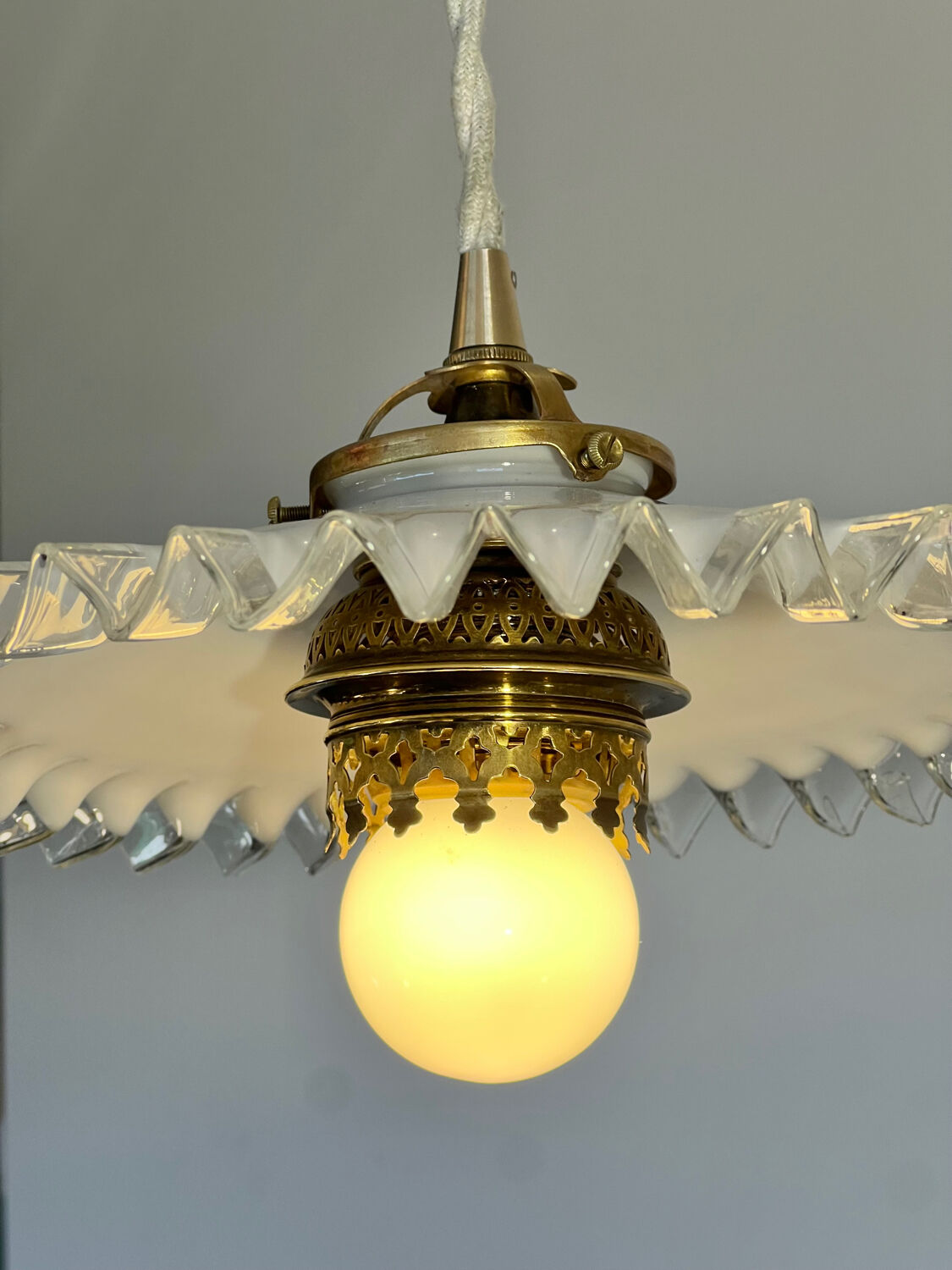 Opaline suspension in Art Deco style with a brass balcony featuring lace details.