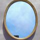 Oval mirror in gold metal