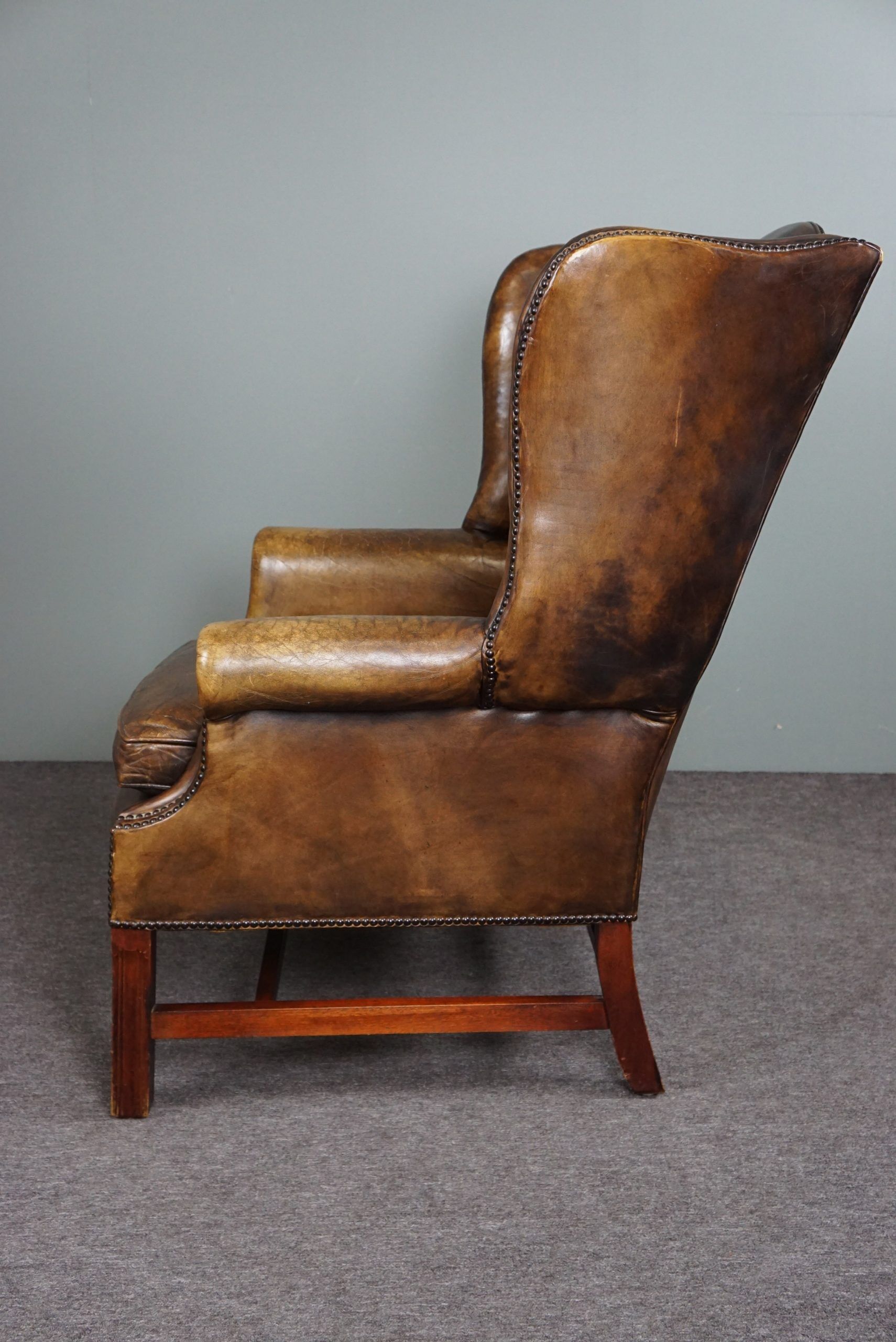 Patinated cowhide leather armchair