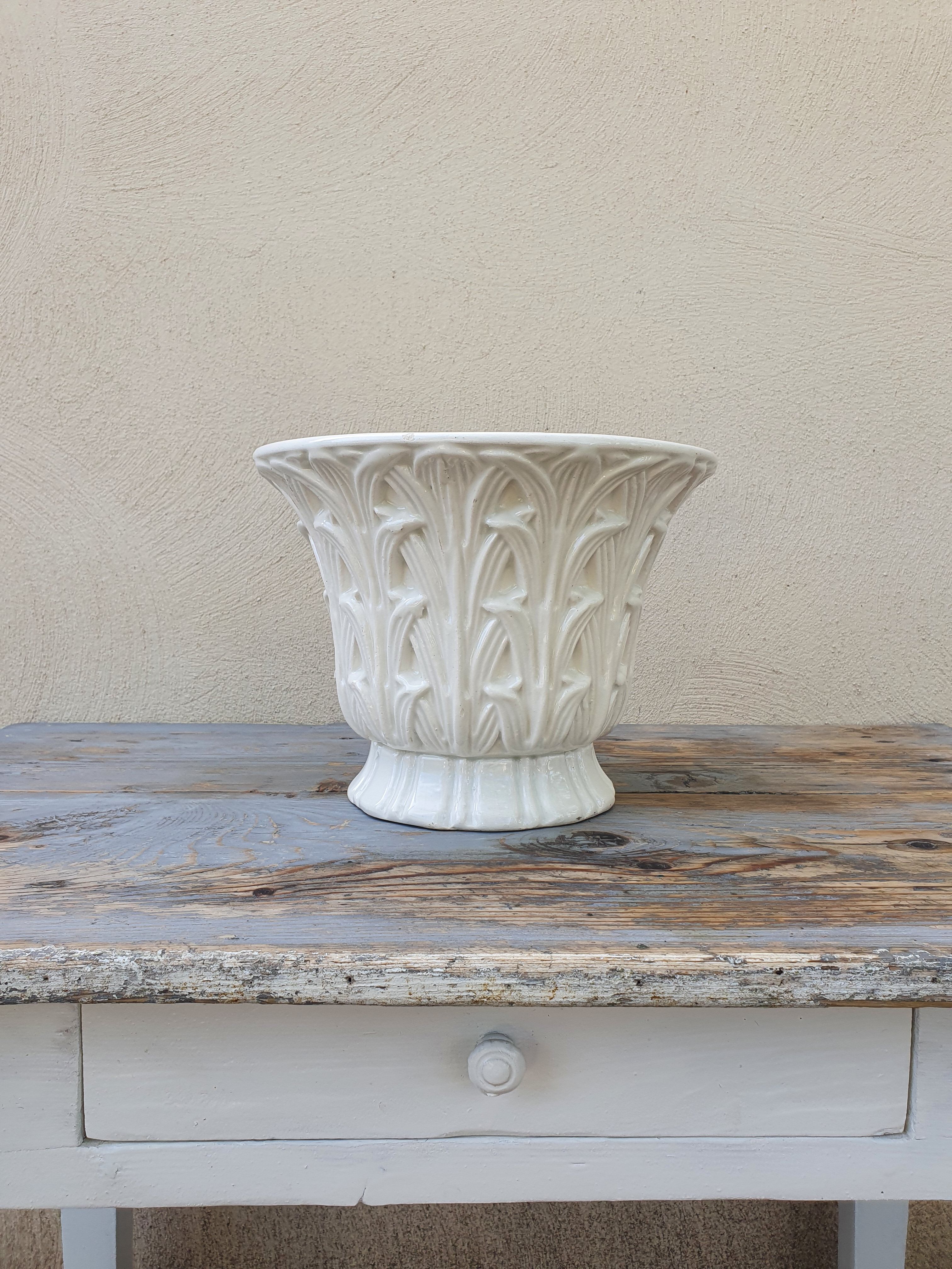 Important white earthenware pot cache with leafy decoration