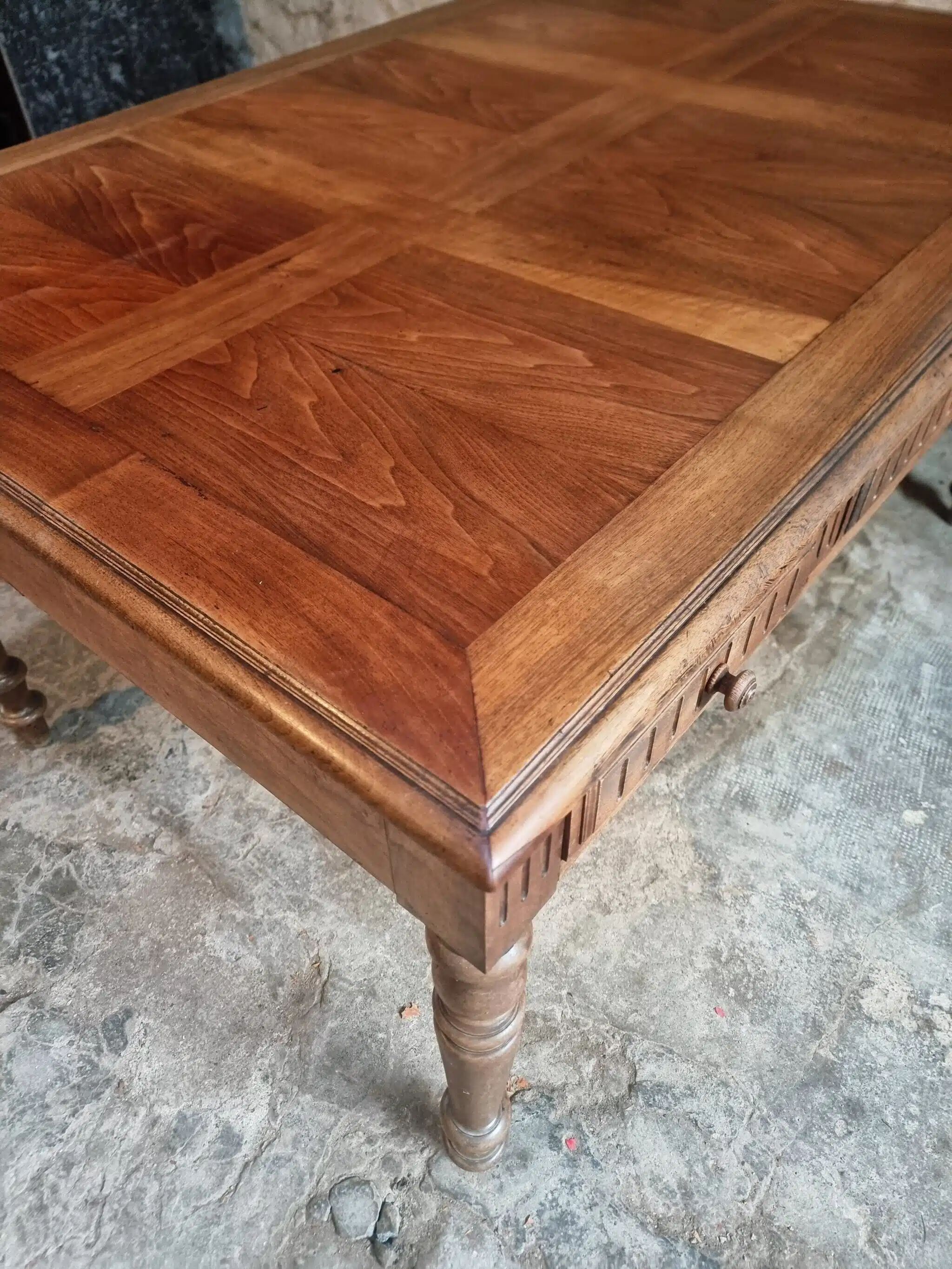 Antique French walnut table with six drawers, parquet top, early 20th century.