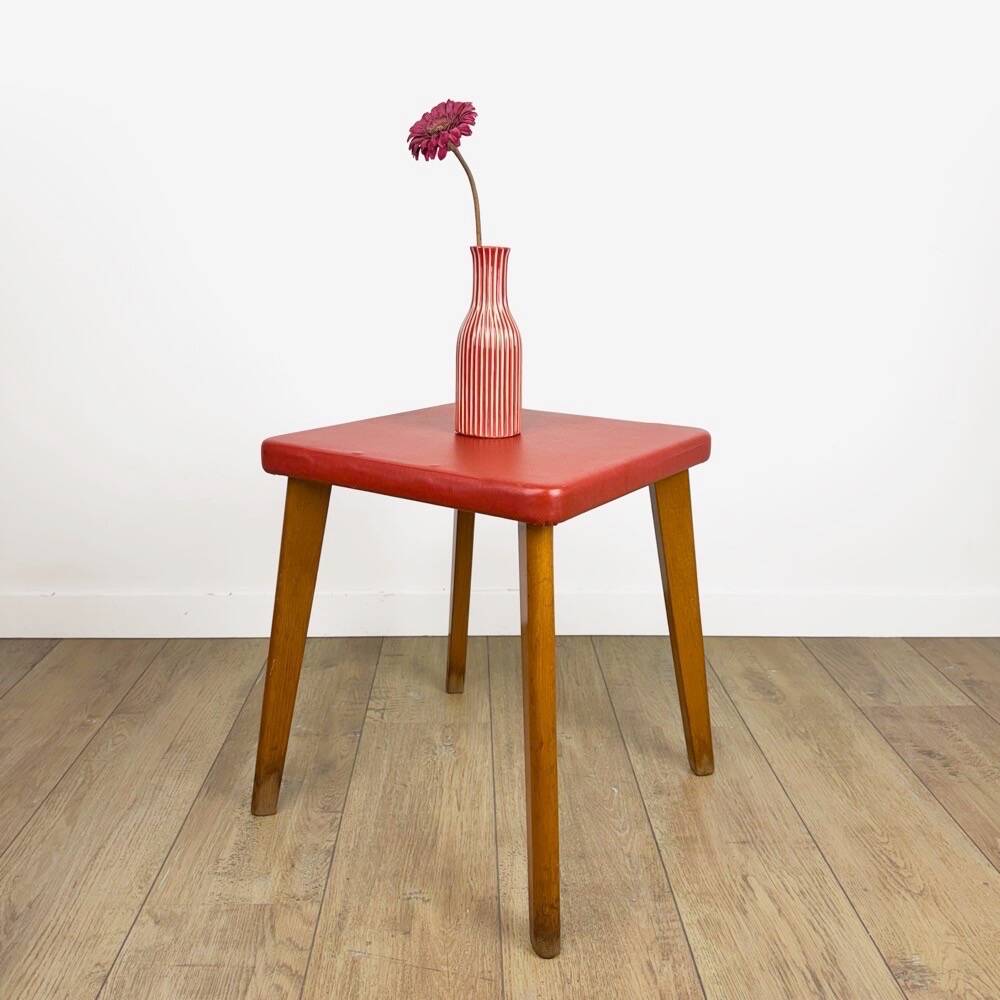 Wooden stool with red faux leather from the 1950s.