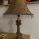 Golden baroque-style table lamp with a shade adorned with pendants.