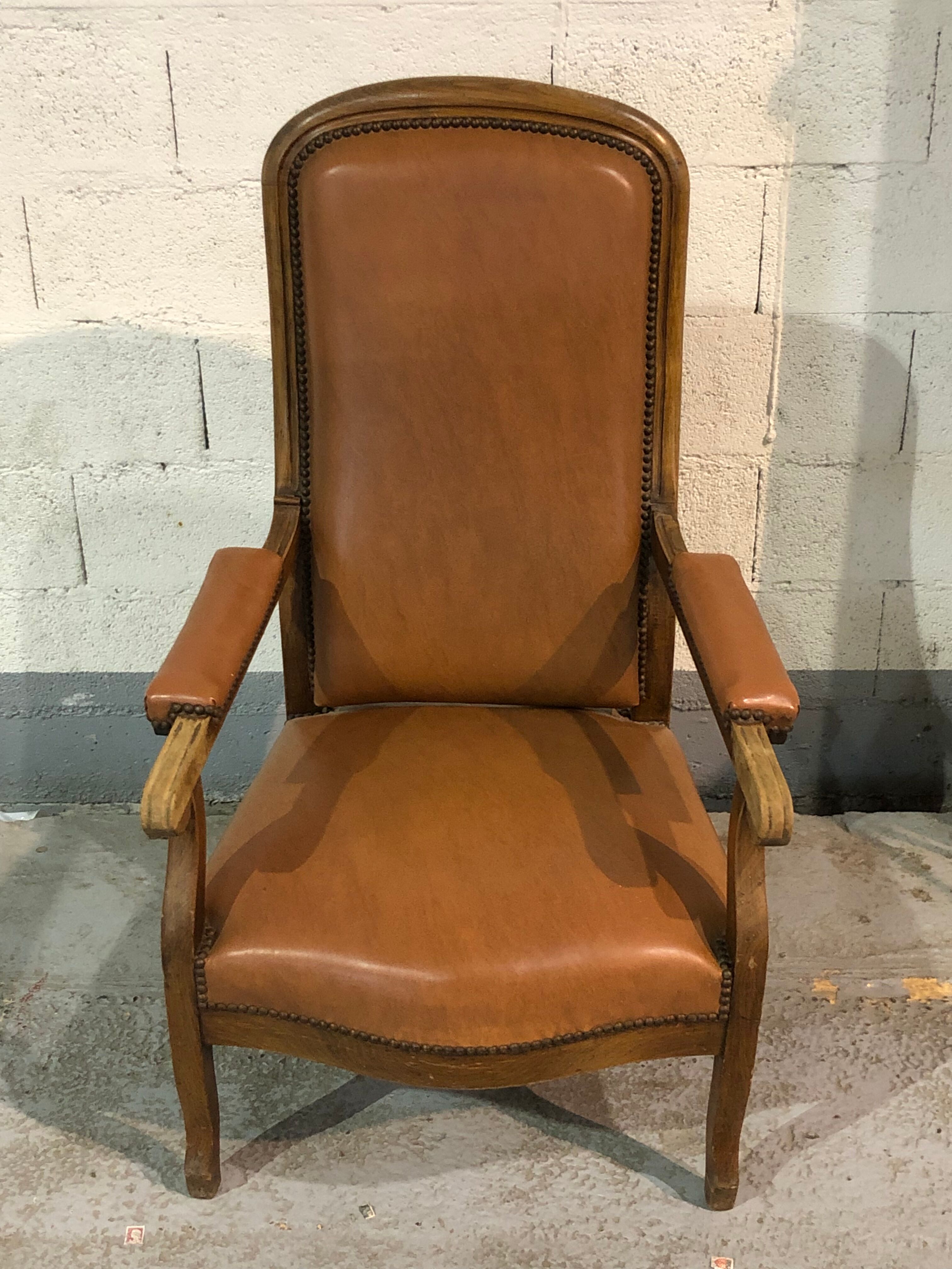 Old Voltaire armchair in light brown leather