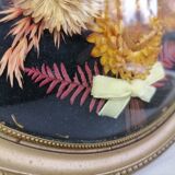 Dried flowers under curved glass frame