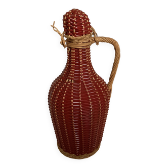 Small decorative bottle in burgundy wicker.