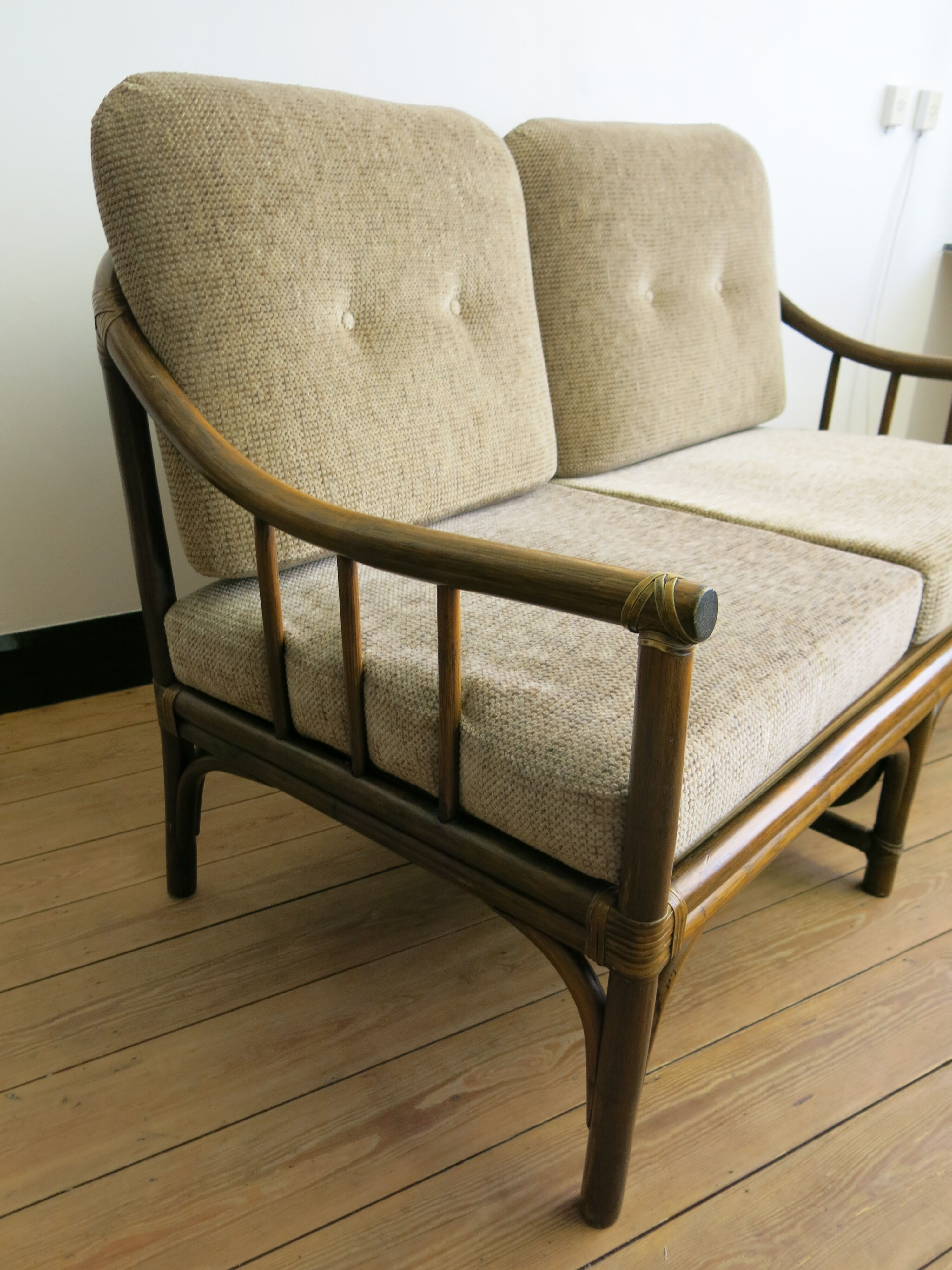 Two-seater rattan sofa with natural tones