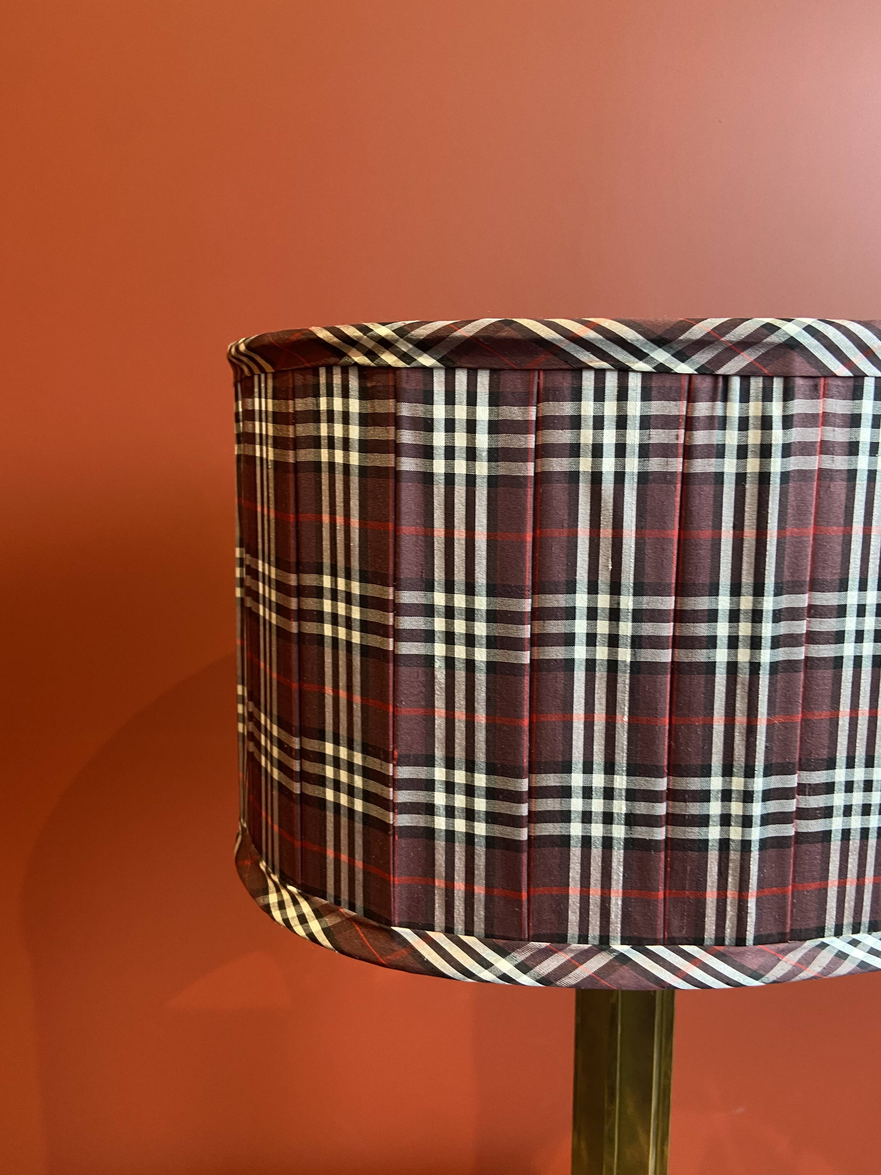 Lamp base in gilded brass, oval silk lampshade with a checkered pattern in burgundy.