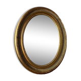 Oval-shaped wooden mirror in gold color