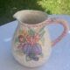 Glazed ceramic slip jug with vintage basket and fruit motif