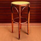 Old high stool in curved wood with caned seat