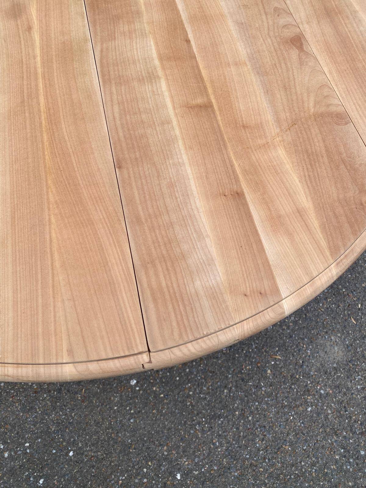 Round dining table with a central pedestal, extendable, stripped in solid walnut with 2 extensions.
