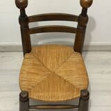 Low fireplace chair in the style of Charles Dudouyt – wood and straw seat.