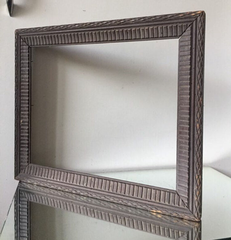 Antique wooden frame with geometric carvings light distress