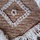 Cushion cover in natural raffia, shells and embroidery in macramé.