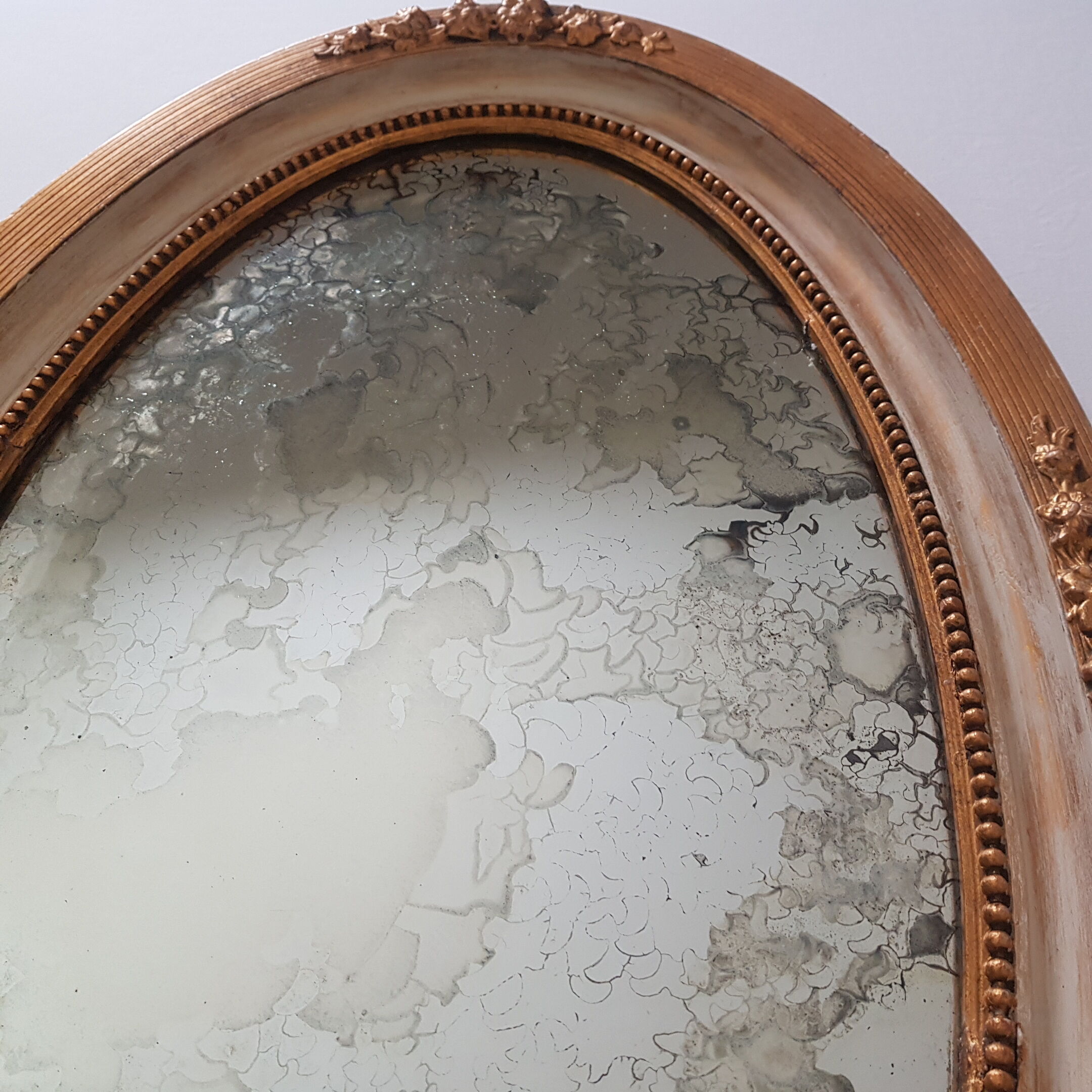 Large oval mirror with bevelled ice in stucque and wood decorated with flowers