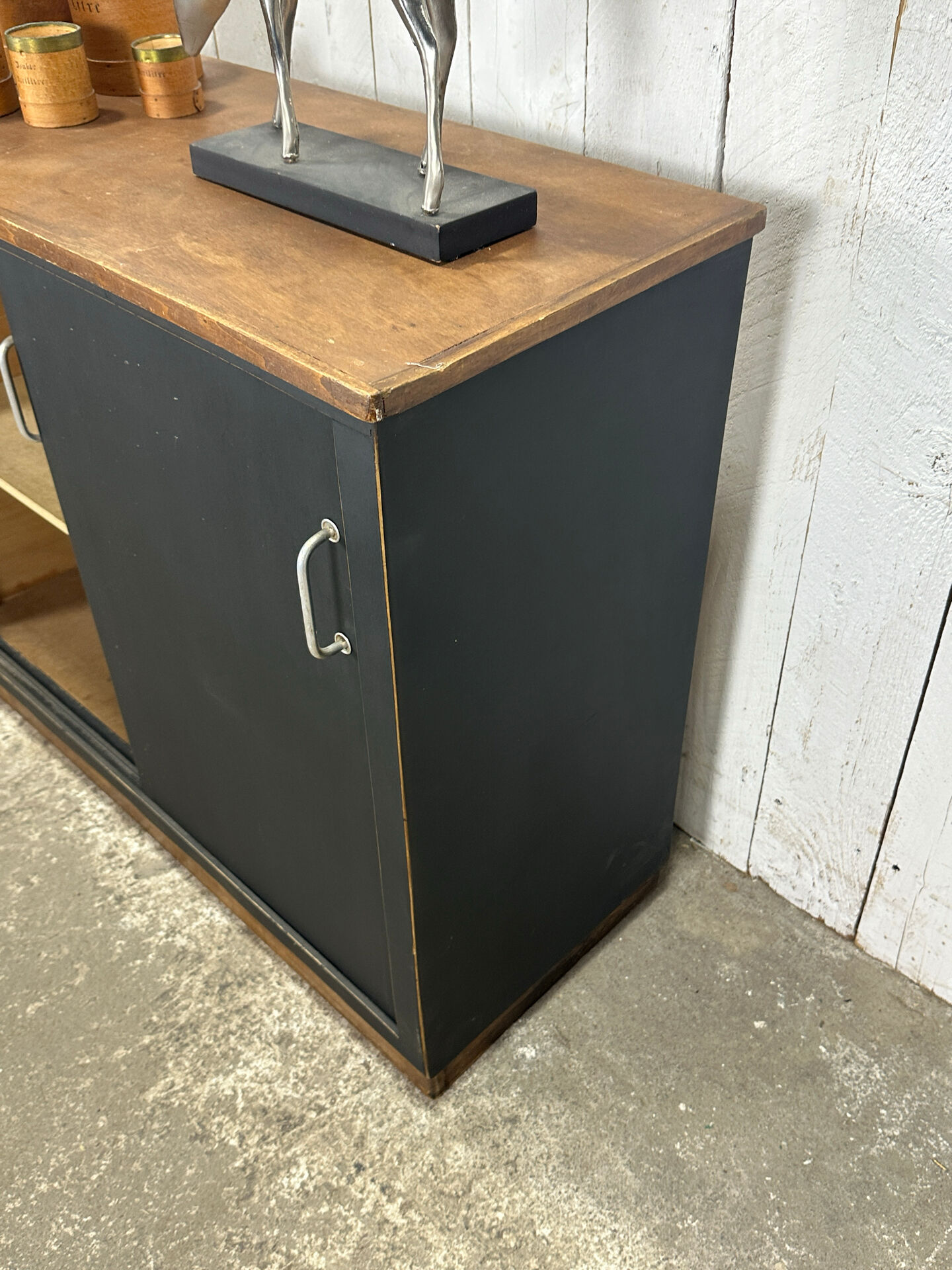 Small vintage black buffet with sliding doors.