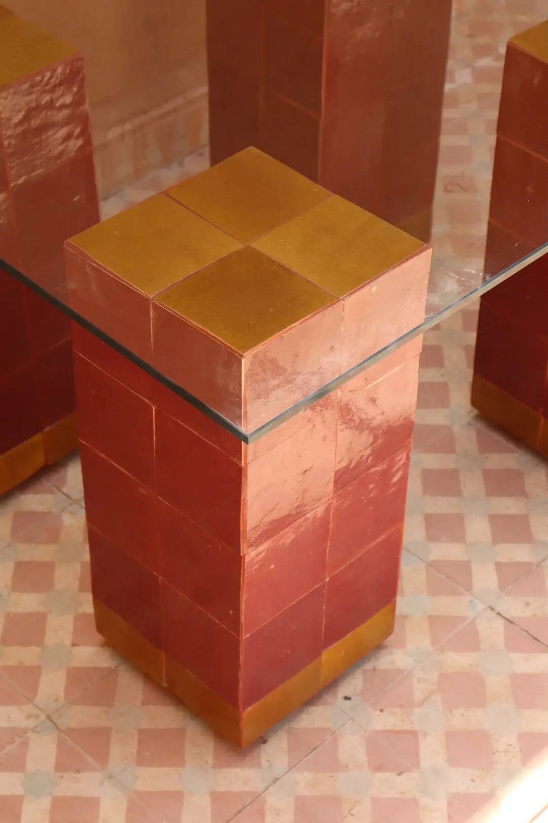 Modern coffee table in burgundy zellige with a tempered glass top.