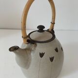 Beige stoneware teapot with stylized flowers and rattan handle
