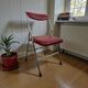 Vintage folding chair in red faux leather with a chrome frame.