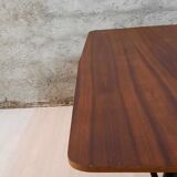 Table à manger en bois de teck et pieds en métal peint.