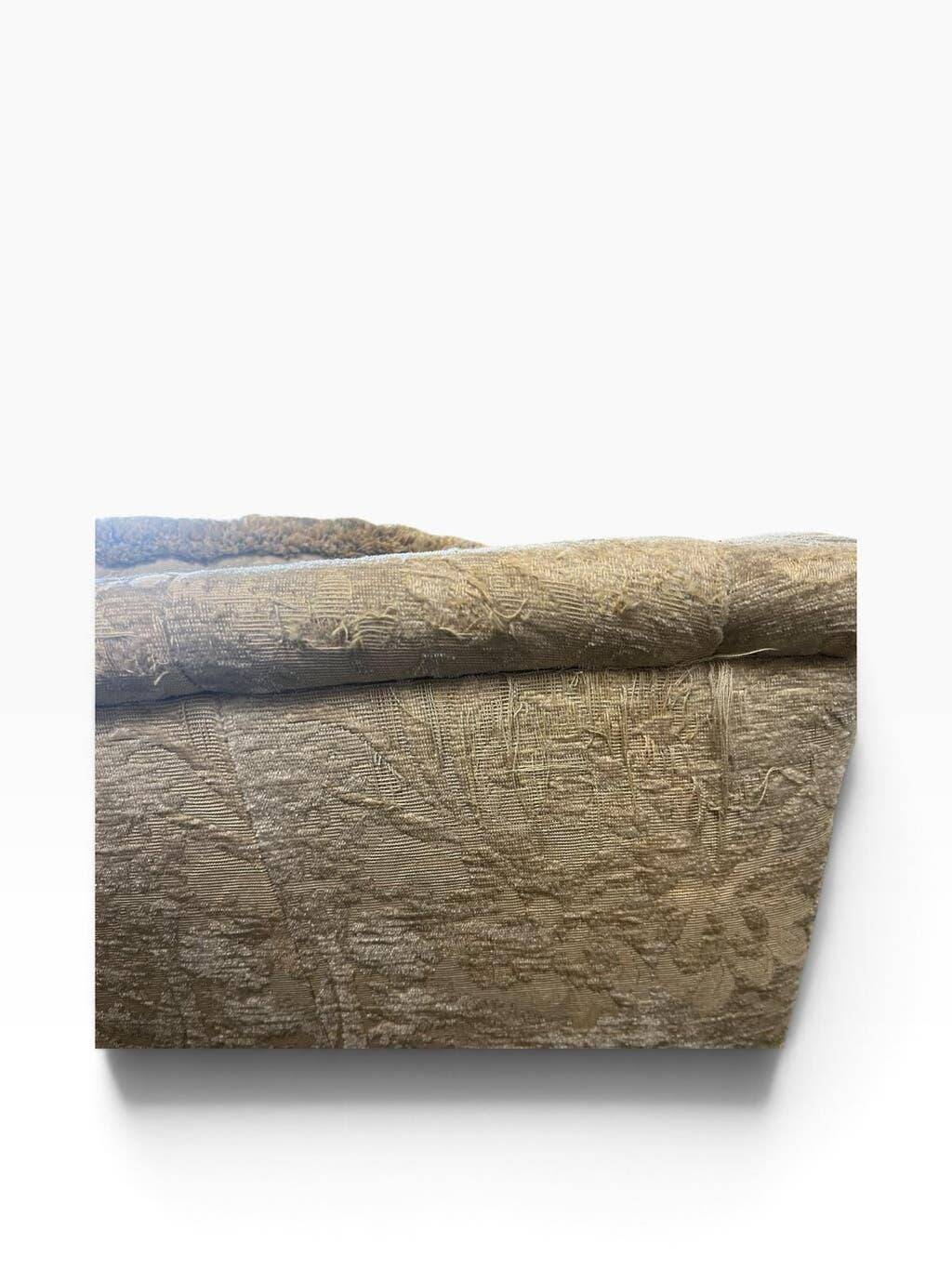 Vintage beige three-seater sofa with floral pattern and fringes.