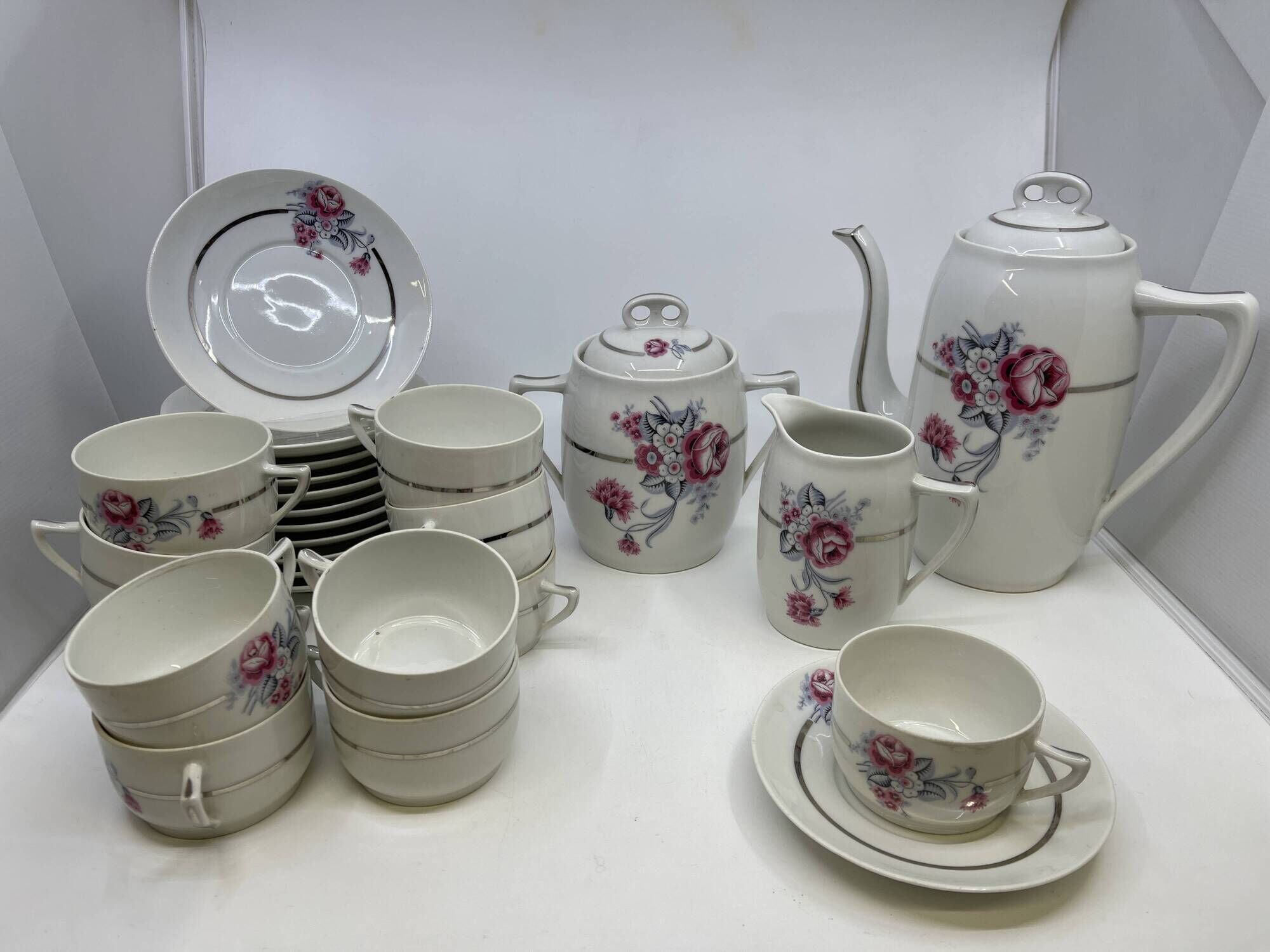 Porcelain coffee service with floral decoration and silver trim.