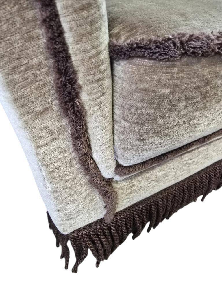 Vintage taupe two-seater canapé with fringes.