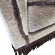 Vintage taupe two-seater canapé with fringes.