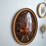 Frame of dried flowers under domed glass