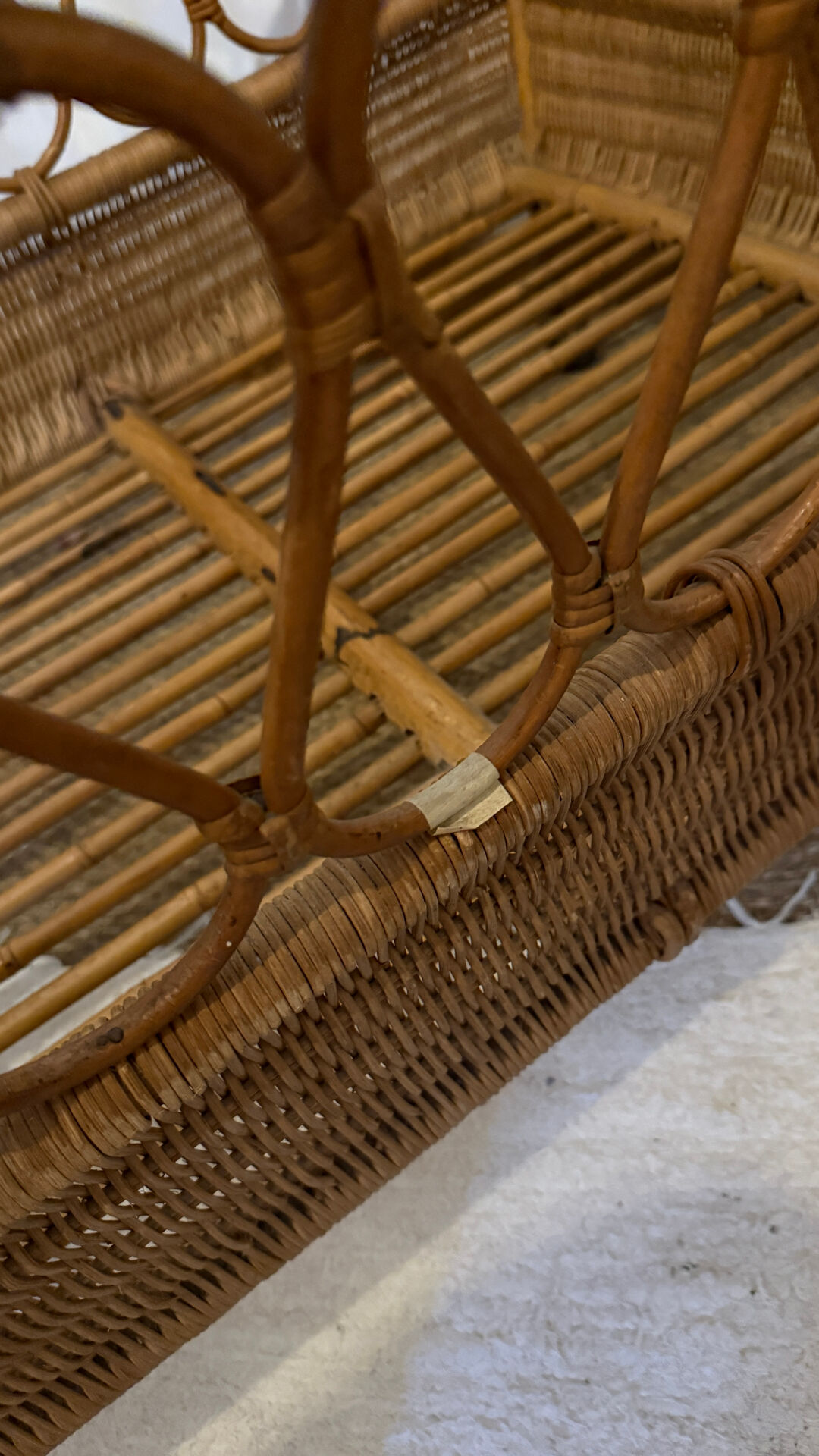 Vintage rattan baby cot on wheels.