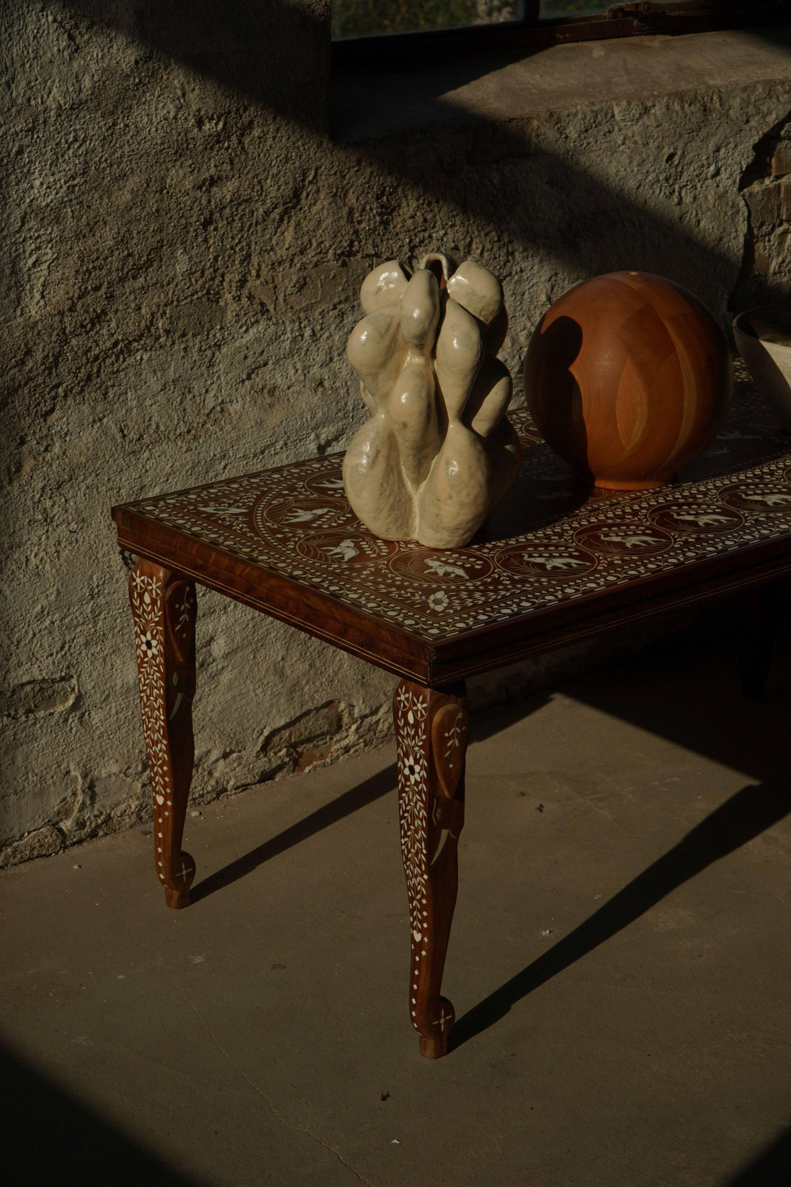 Vintage Indian teak coffee table inlaid with elephant motifs, mid-20th century.