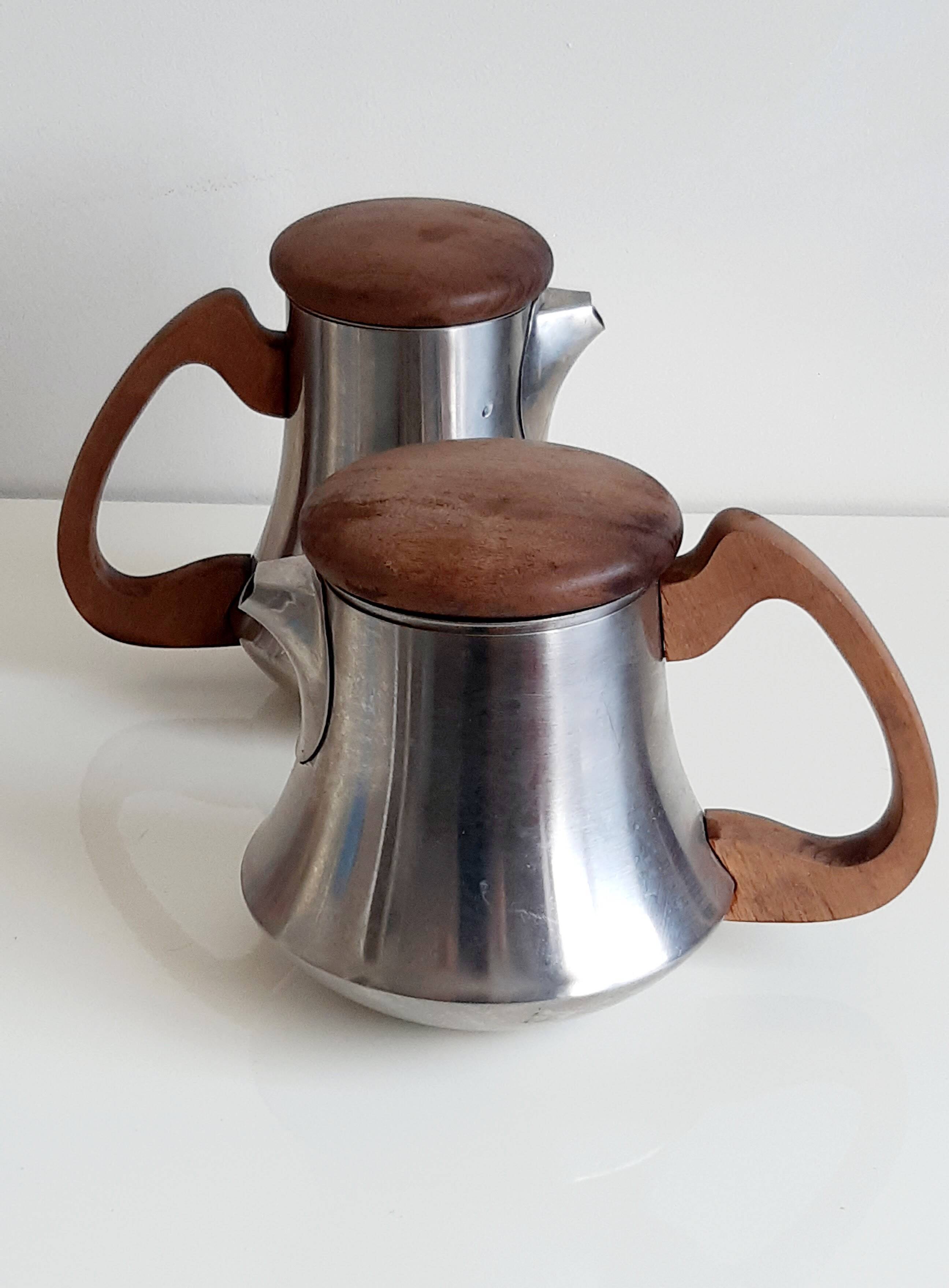 Letang and Remy tea and coffee service in plain stainless steel, exotic wood handles and lids.