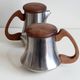 Letang and Remy tea and coffee service in plain stainless steel, exotic wood handles and lids.