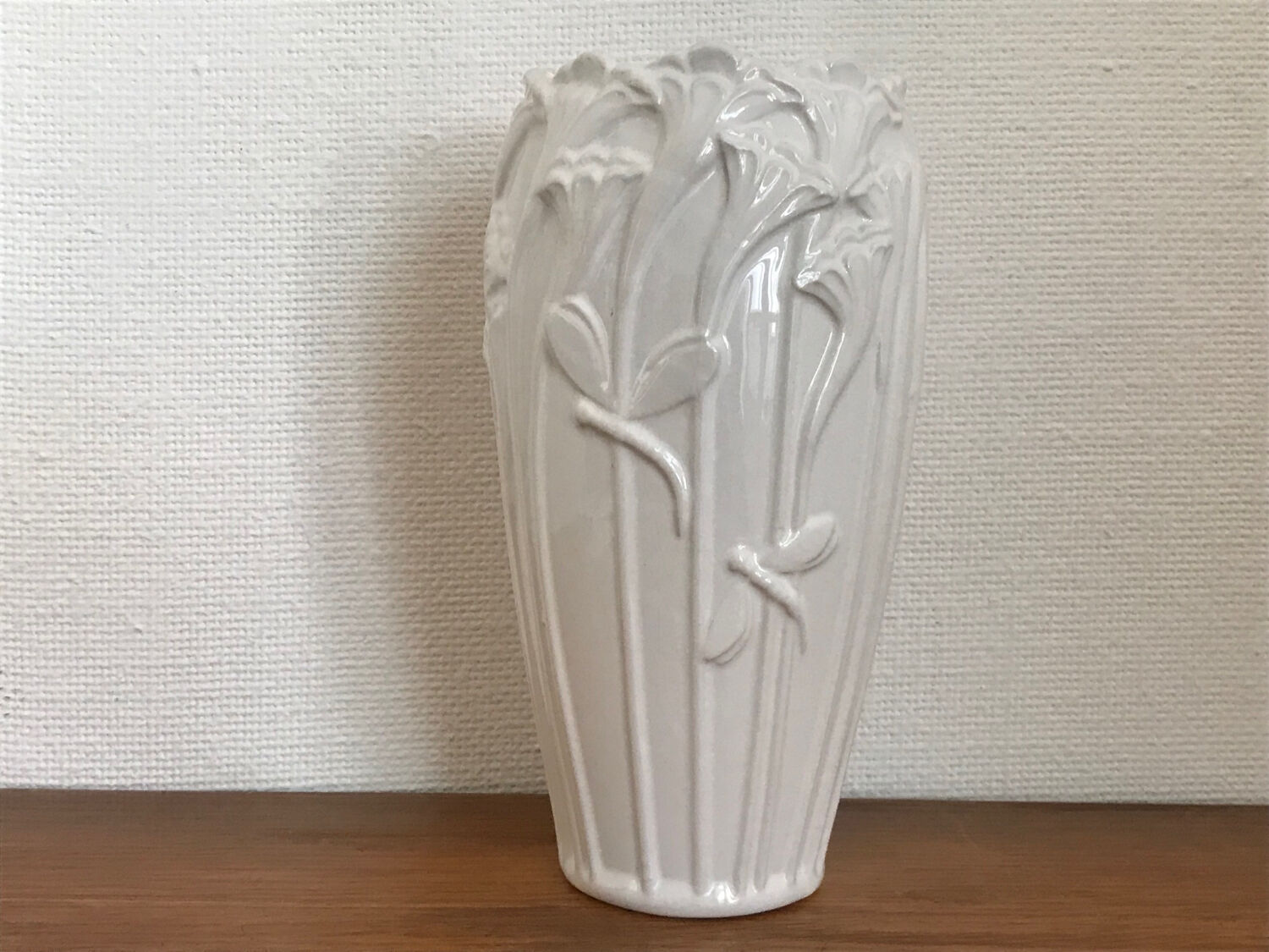 Old white art nouveau vase with flowers and dragonflies