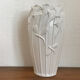 Old white art nouveau vase with flowers and dragonflies